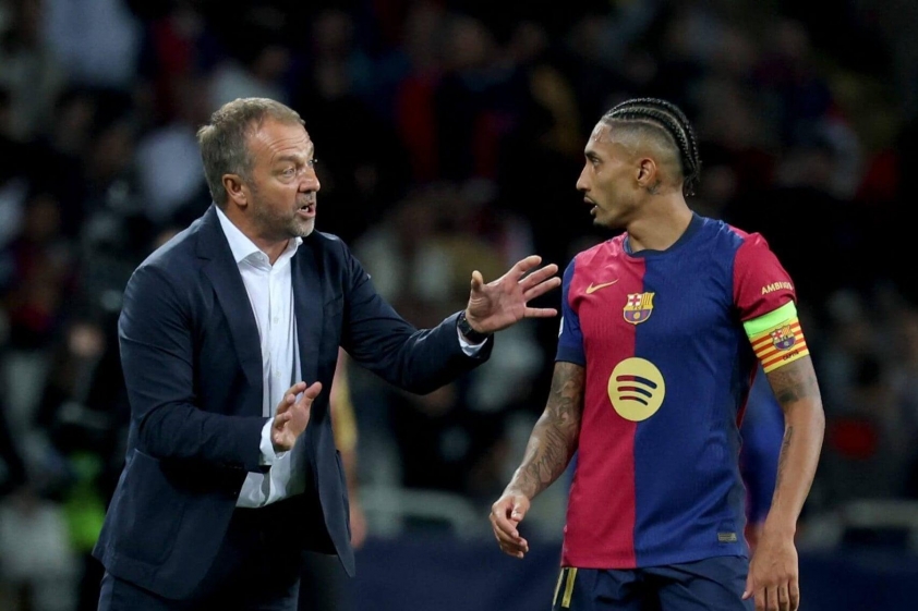 Hansi Flick chỉ đạo Raphinha trên sân tập hoặc trong trận đấu.